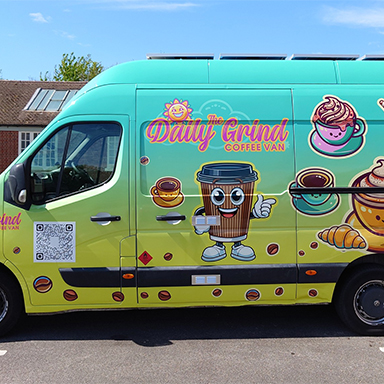 A van featuring a colorful cartoon design, showcasing playful characters and vibrant patterns, including the wording: The Daily Grind and their mascot Brewster.